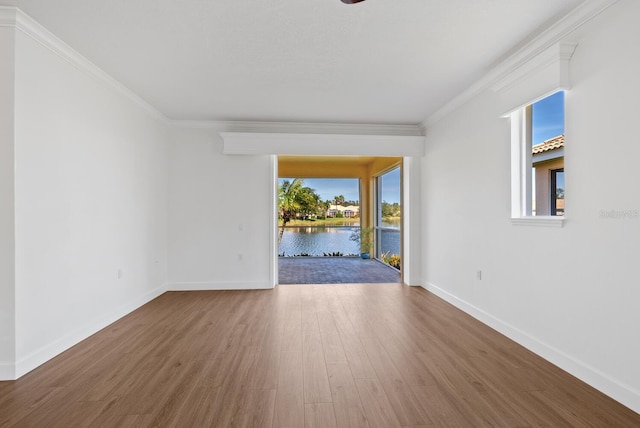 unfurnished room with a water view, ornamental molding, and wood-type flooring