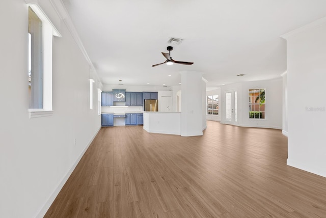 unfurnished living room featuring hardwood / wood-style flooring, crown molding, and ceiling fan