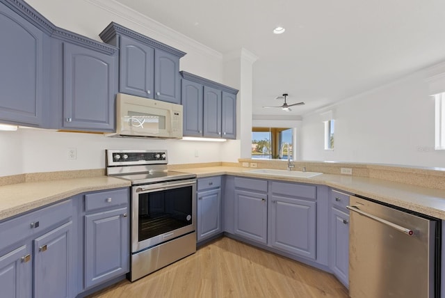 kitchen with sink, crown molding, light hardwood / wood-style flooring, blue cabinetry, and appliances with stainless steel finishes