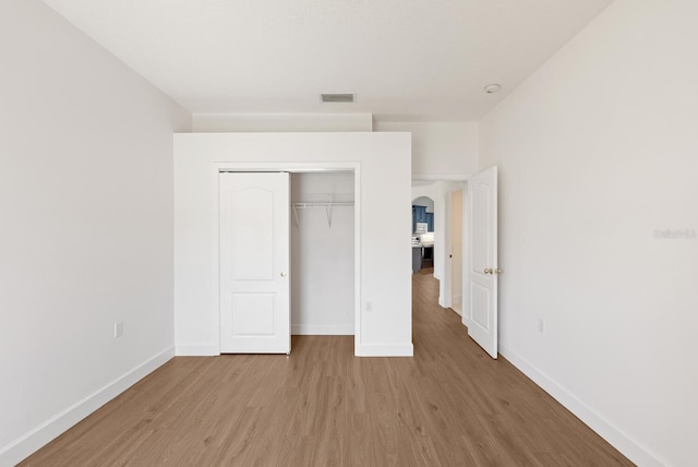 unfurnished bedroom featuring a closet and light wood-type flooring