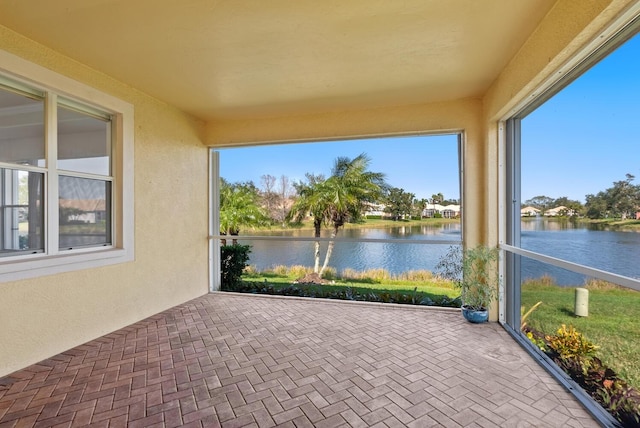 unfurnished sunroom with a water view