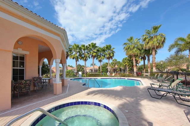 view of pool with a hot tub and a patio area