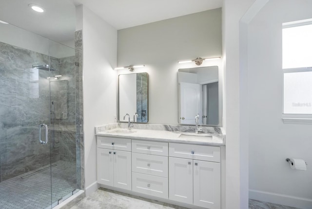 bathroom with double vanity, baseboards, and a sink