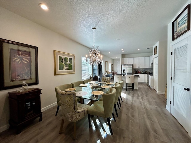 dining area featuring a notable chandelier, baseboards, wood finished floors, and recessed lighting