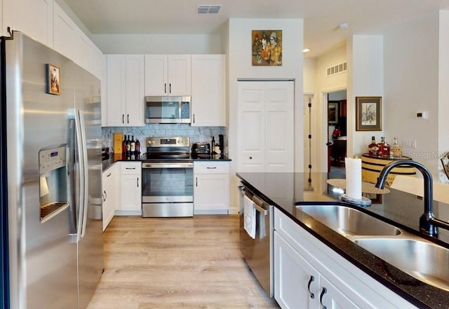 kitchen featuring white cabinetry, sink, tasteful backsplash, and stainless steel appliances