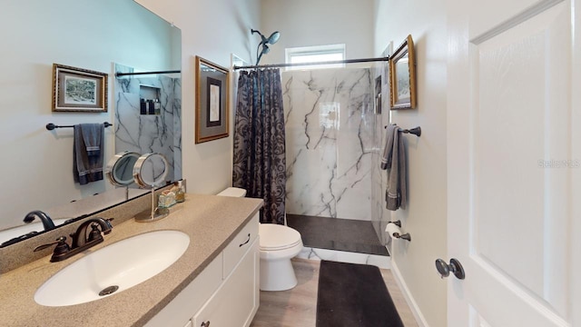 bathroom with toilet, a marble finish shower, wood finished floors, and vanity