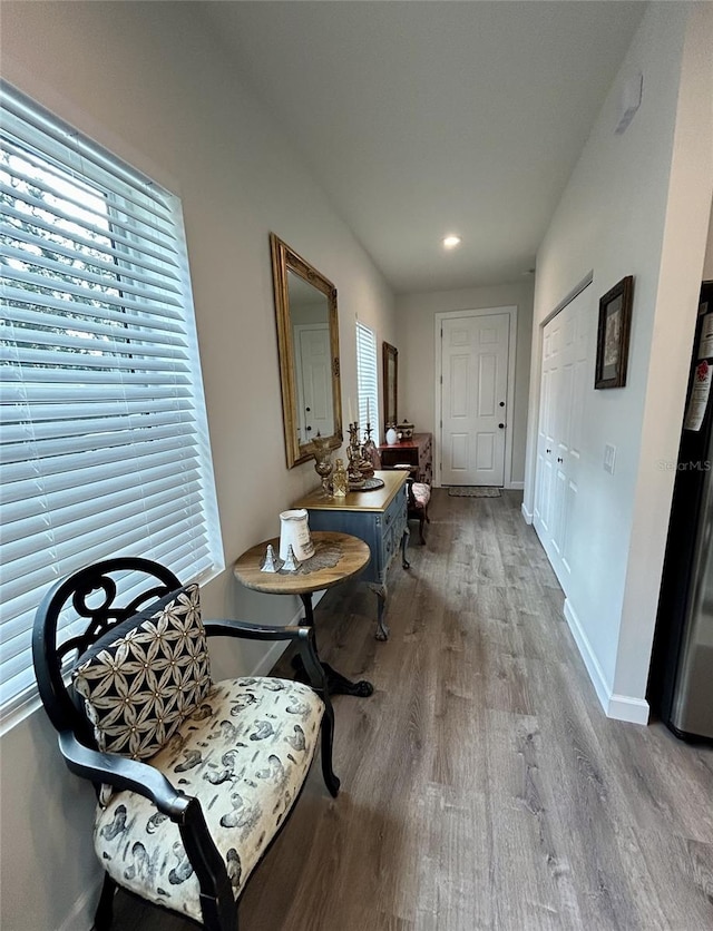 corridor featuring light wood-type flooring and baseboards