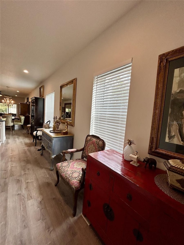 sitting room with recessed lighting, an inviting chandelier, and wood finished floors