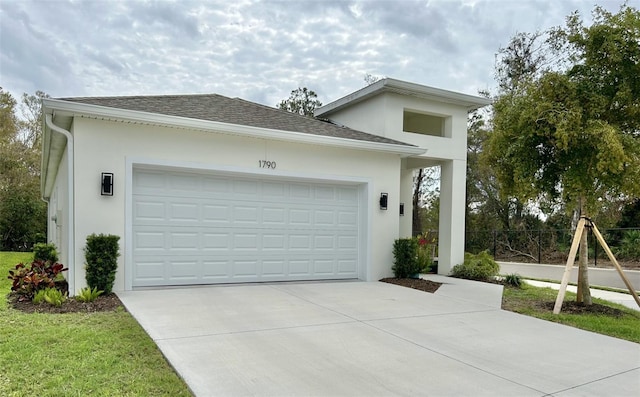 garage featuring concrete driveway and fence