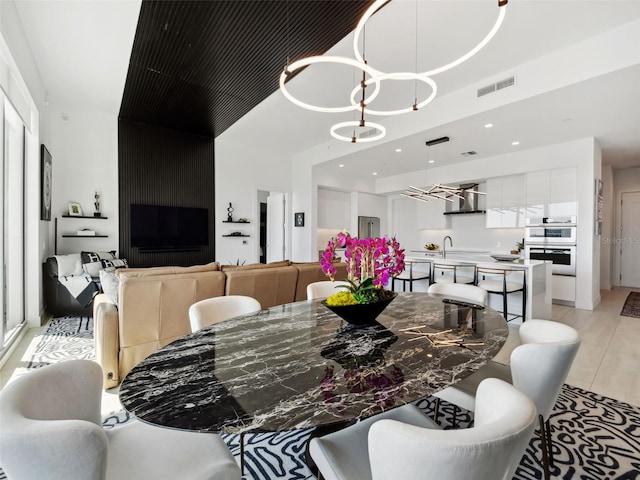 tiled dining area with an inviting chandelier and sink