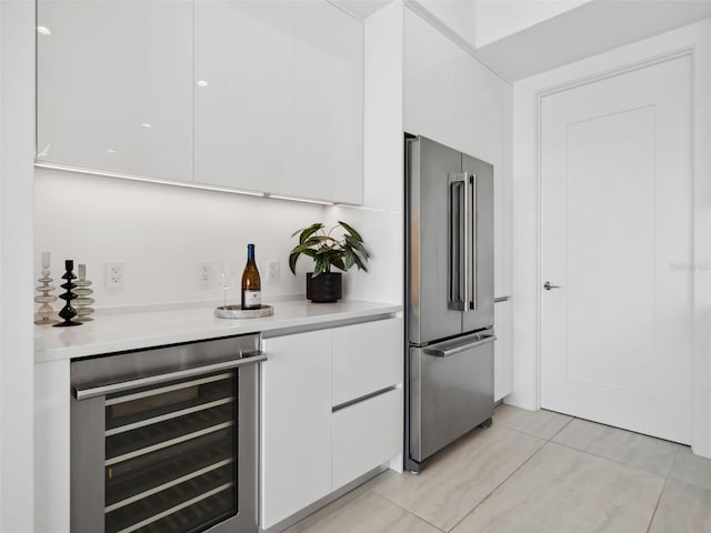 kitchen with high quality fridge, beverage cooler, and white cabinets