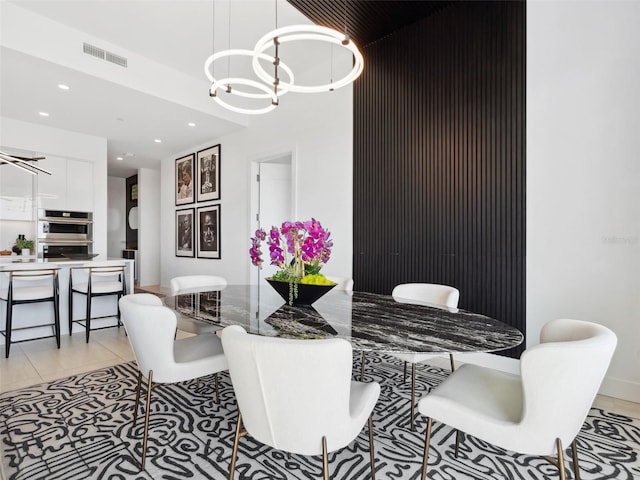 dining area with light tile patterned floors and a notable chandelier