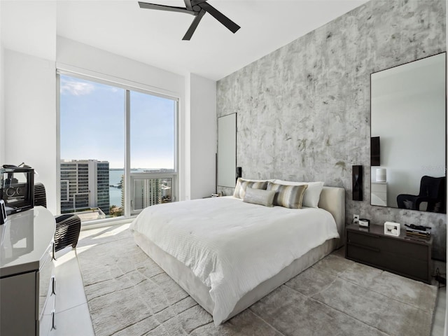 bedroom featuring a water view and ceiling fan