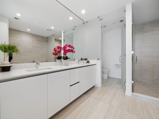 bathroom featuring vanity, walk in shower, tile patterned floors, and toilet