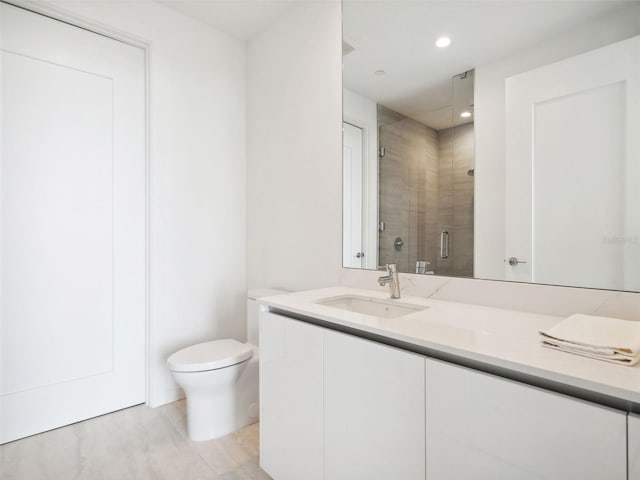 bathroom with vanity, walk in shower, and toilet