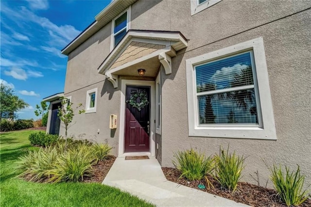 view of exterior entry with a lawn