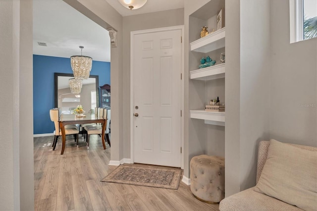 interior space with an inviting chandelier and light hardwood / wood-style floors