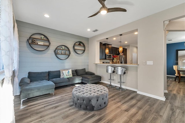 living room with ceiling fan and dark hardwood / wood-style flooring