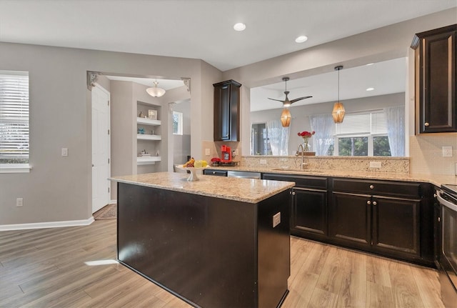 kitchen with pendant lighting, a center island, kitchen peninsula, and sink