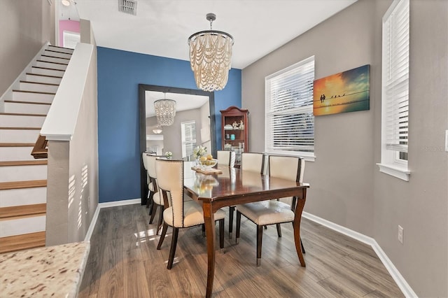 dining space with hardwood / wood-style flooring and a chandelier