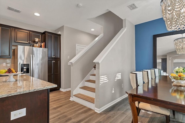 stairs with a notable chandelier and hardwood / wood-style flooring