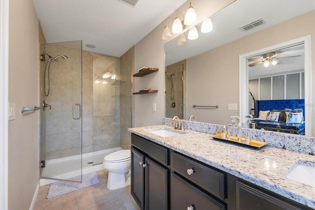 bathroom featuring tile patterned flooring, vanity, walk in shower, and toilet