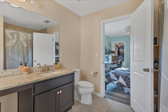 bathroom featuring tile patterned flooring, vanity, and toilet