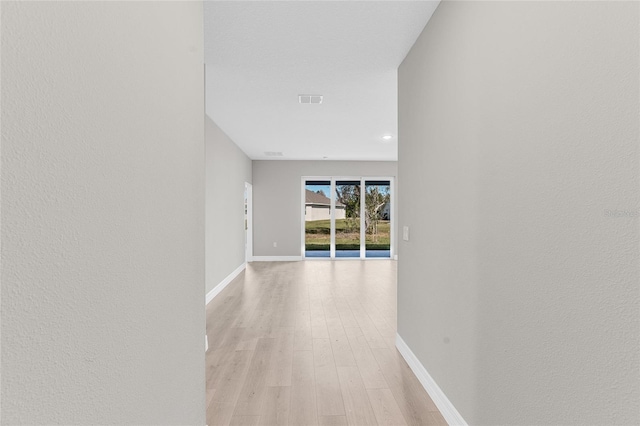 hallway with light hardwood / wood-style floors