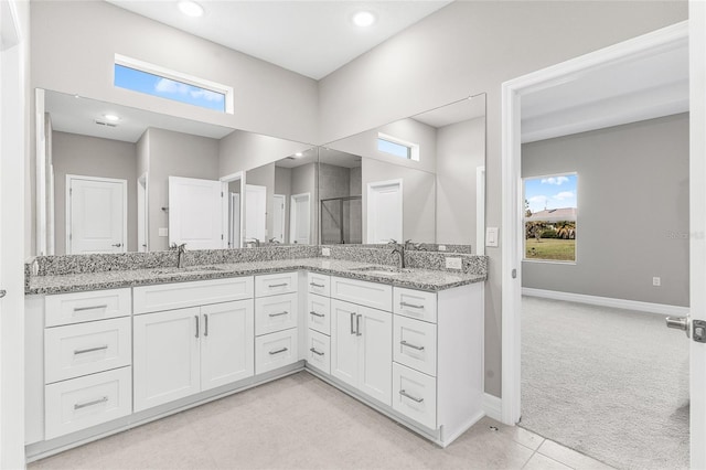 bathroom with walk in shower, tile patterned floors, plenty of natural light, and vanity