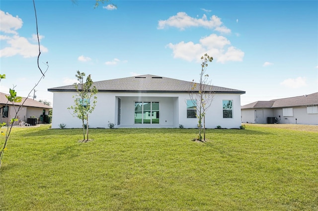 rear view of house featuring a lawn and central air condition unit