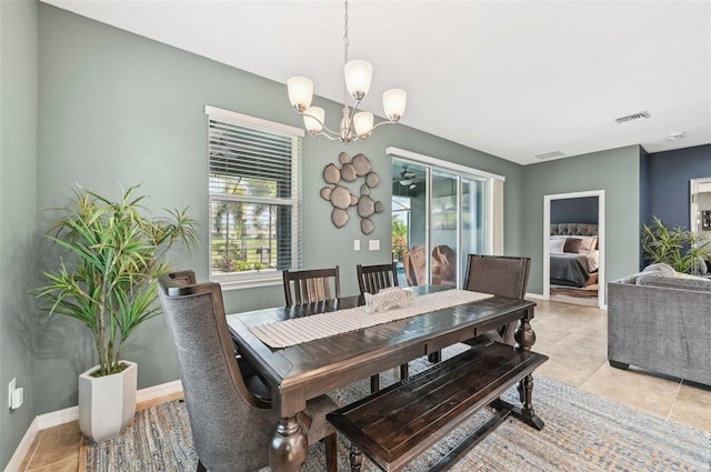 dining area with a notable chandelier, baseboards, visible vents, and light tile patterned floors