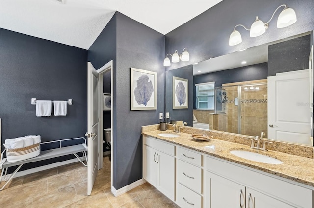 full bath featuring double vanity, baseboards, a stall shower, and a sink