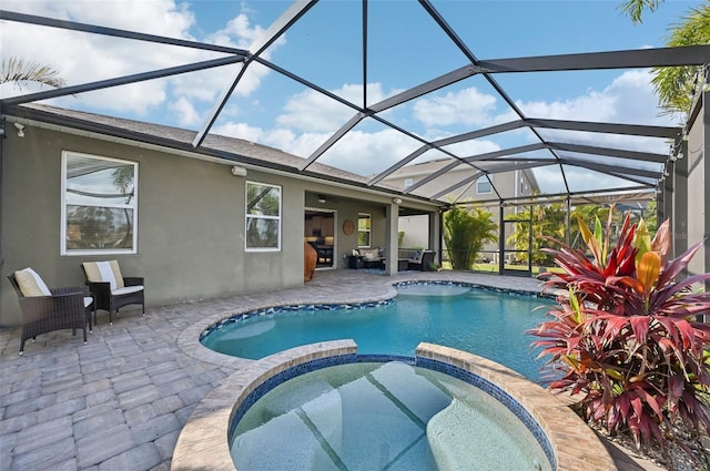 view of swimming pool featuring glass enclosure, a pool with connected hot tub, and a patio