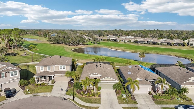 drone / aerial view with golf course view, a water view, and a residential view