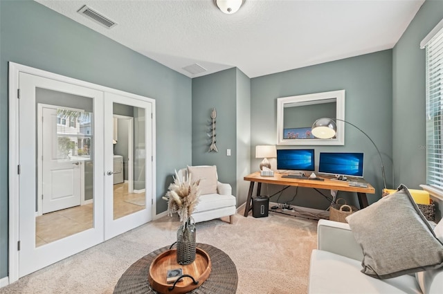 interior space featuring visible vents, washer / clothes dryer, french doors, and a textured ceiling