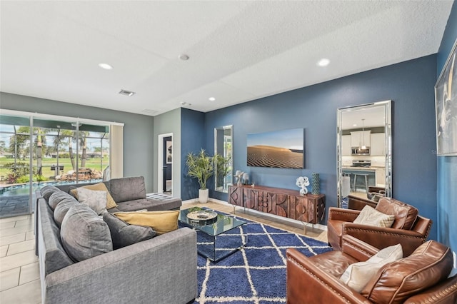 living area featuring visible vents, baseboards, recessed lighting, tile patterned floors, and a textured ceiling