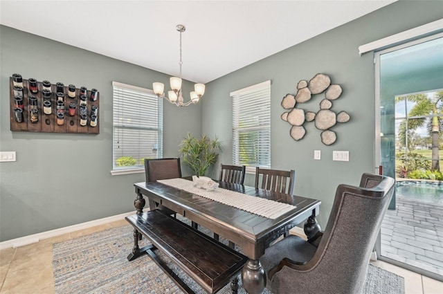 tiled dining space with a notable chandelier, baseboards, and a wealth of natural light