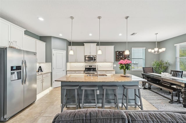 kitchen featuring tasteful backsplash, visible vents, a breakfast bar, light tile patterned floors, and appliances with stainless steel finishes