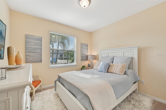 bedroom featuring baseboards and light carpet