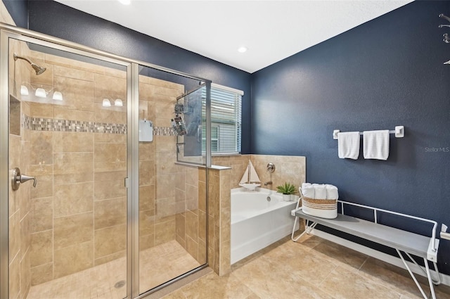 bathroom featuring a bath, tile patterned flooring, and a stall shower