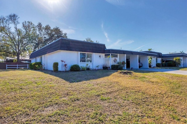 ranch-style home with a carport and a front yard