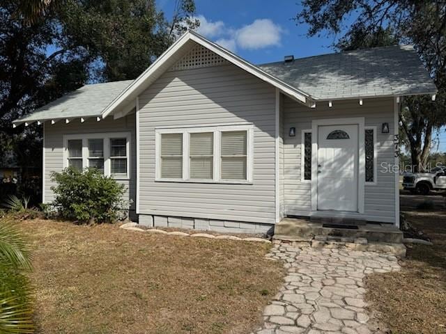 rear view of property featuring a lawn