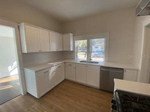 kitchen with white cabinetry, stainless steel appliances, sink, and light wood-type flooring