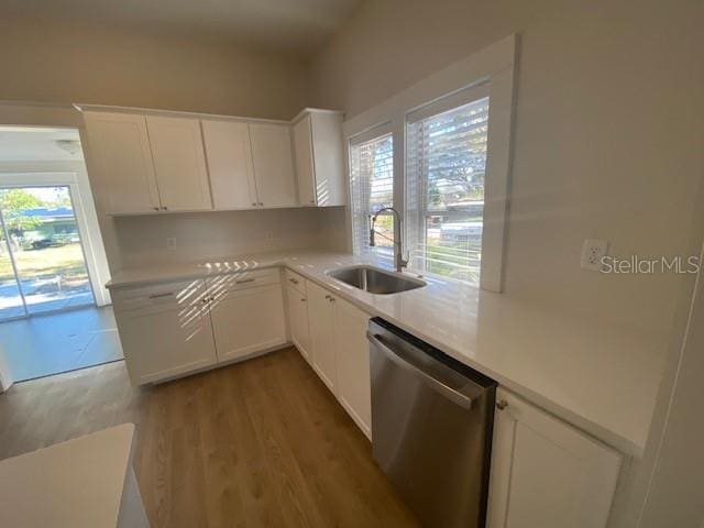 kitchen with sink, dishwasher, backsplash, light hardwood / wood-style floors, and white cabinets