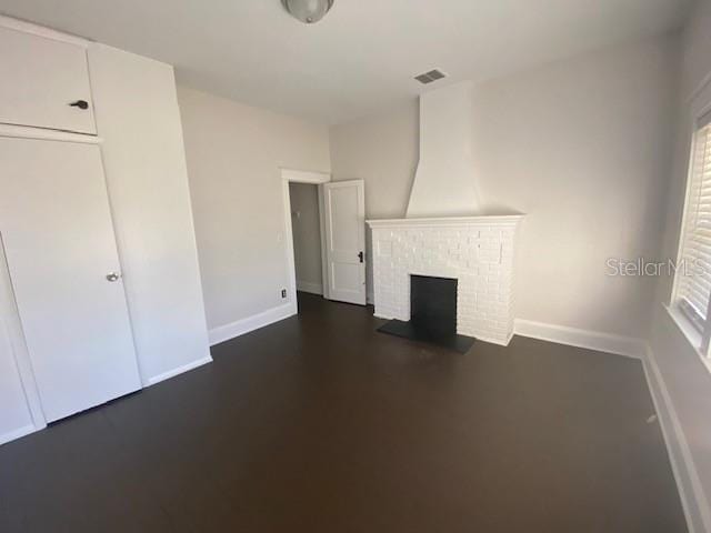 unfurnished living room featuring a brick fireplace