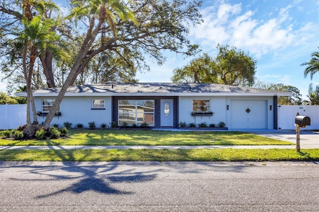 ranch-style home with a garage and a front lawn