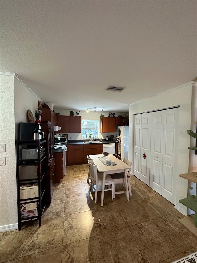 kitchen with sink, crown molding, a textured ceiling, and appliances with stainless steel finishes