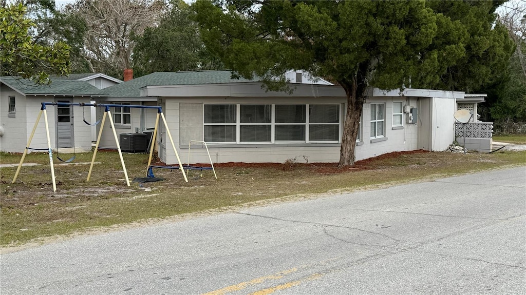 back of property featuring a playground and central AC unit