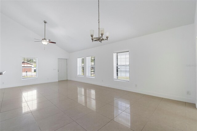 tiled spare room featuring ceiling fan with notable chandelier and high vaulted ceiling