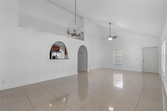 unfurnished room with ceiling fan with notable chandelier, high vaulted ceiling, and light tile patterned flooring